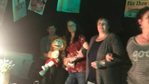 Mehrere Frauen stehen nebeneinander und schauen sich ein Konzert an